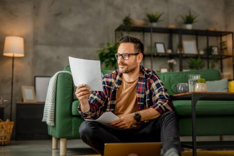 homme assis dans son salon vérifie ses diagnostics immobiliers