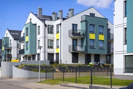 Résidence avec des bâtiments blanc, jaune et bleu canard.