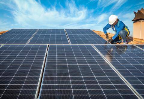 Une femme installe des panneaux solaires