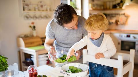 Un jeune papa en train de cuisiner avec son enfant