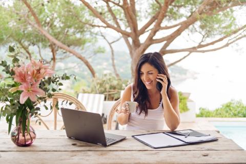 femme sur sa terrasse téléphone et regarde son ordinateur