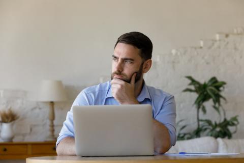 homme réfléchit devant son ordinateur