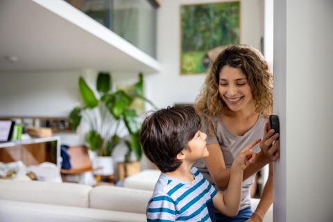 Une mère montre à son fils comment programmer le thermostat