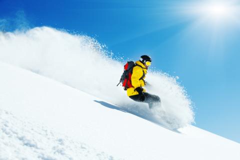 Snowboarder avec doudoune jaune dans les Alpes
