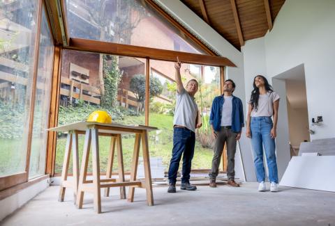 Couple avec entrepreneur regardent les travaux de rénovation réalisés dans leur maison 