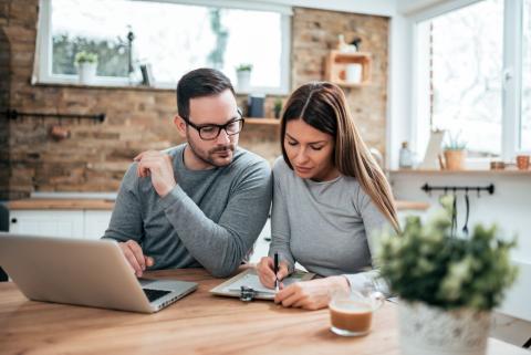 couple prend des notes pour réussir sa location meublée