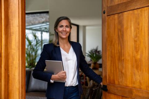 Agent immobilier femme qui ouvre la porte d'entrée.