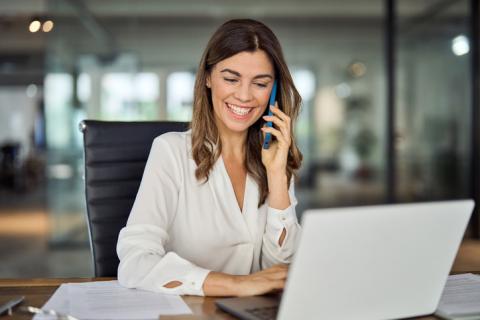 Un agent immobilier femme sur son ordinateur parle au téléphone.