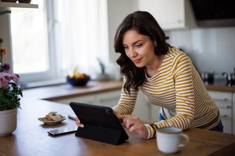 femme-lit-les-actualites-sur-sa-tablette-dans-sa-cuisine