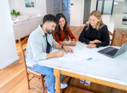 Un couple d'acquéreurs et une femme agent immobilier.