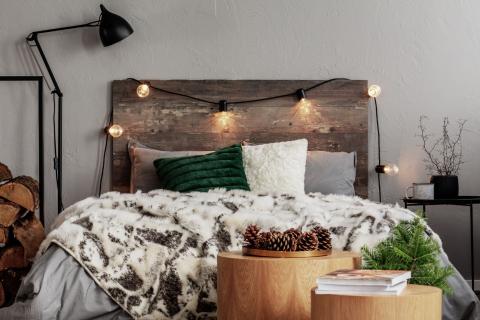 Chambre à la déco chaleureuse avec tête de lit en bois et guirlande lumineuse
