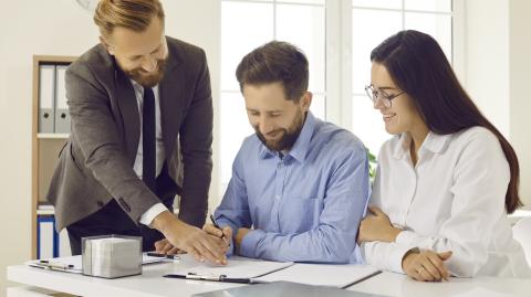 Un couple signe des documents officiels en présence de son notaire