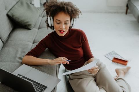 Jeune femme relit sa lettre de résiliation de bail près de son ordinateur