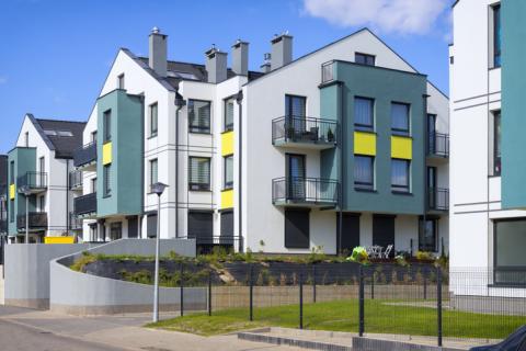 Résidence avec des bâtiments blanc, jaune et bleu canard.