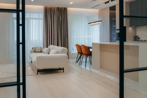 Petit appartement de luxe et décoration épurée avec canapé blanc et portes vitrées. 