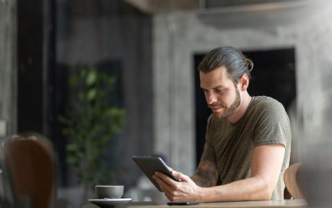 Attractive Beard man sitting using digital tablet