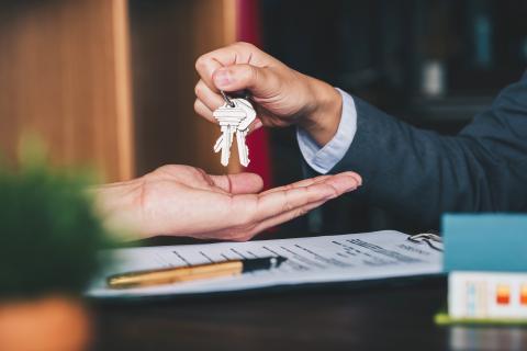 estate agent giving house keys to woman and sign agreement in office estate agent giving house keys to woman and sign agreement in office