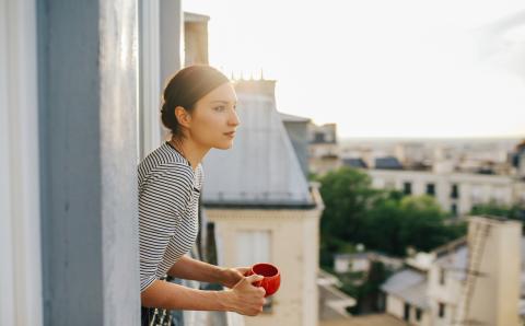 Young woman enjoying the view from a Parisian apartment