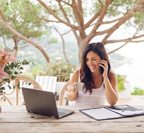 femme sur sa terrasse téléphone et regarde son ordinateur