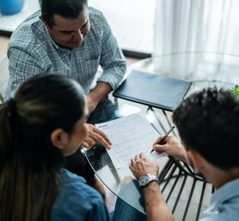 Un couple signant une promesse de location avec le propriétaire