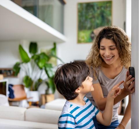 Une mère montre à son fils comment programmer le thermostat