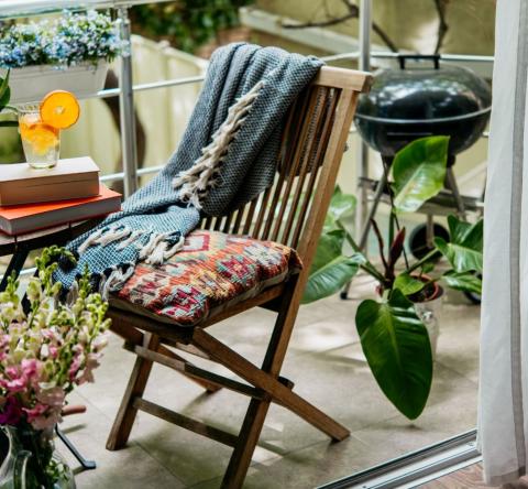 petit balcon avec plantes, table, chaise et barbecue