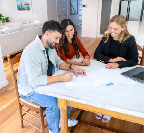 Un couple d'acquéreurs et une femme agent immobilier. 