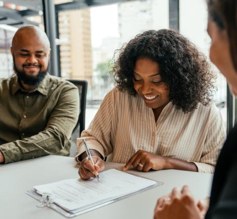 Un couple signe son contrat chez le notaire pour devenir propriétaire.