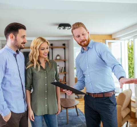 Un agent immobilier expert fait visiter un appartement à un couple homme, femme. 
