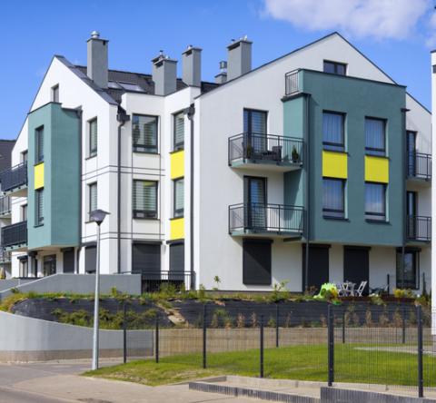 Résidence avec des bâtiments blanc, jaune et bleu canard.