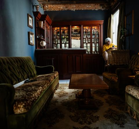 Salon très sombre, de style victorien, avec de gros meubles. 