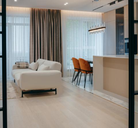 Petit appartement de luxe et décoration épurée avec canapé blanc et portes vitrées. 