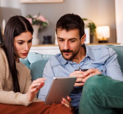 couple recherche sur sa tablette le montant minimum de l'apport pour acheter une maison 
